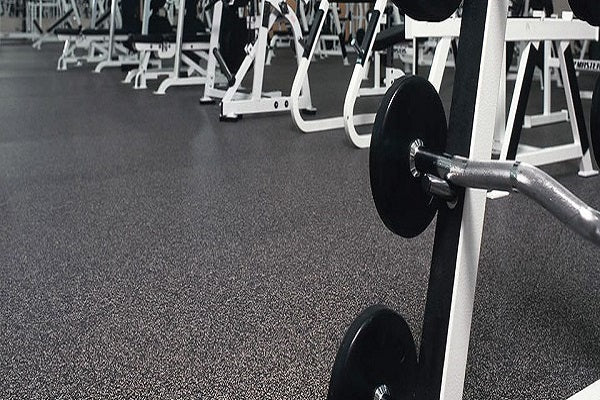 Galaxy Plus Rubber Gym Flooring Rolls - 48-Inch Wide, Recycled Rubber, Slip-Resistant, USA Made installed beneath weightlifting equipment in a gym; rubber gym flooring rolls application
