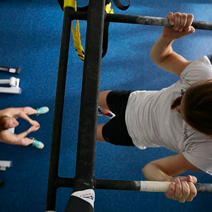 Galaxy Plus Rubber Gym Flooring Rolls - 48-Inch Wide, Recycled Rubber, Slip-Resistant, USA Made beneath athletes performing pull-ups in a training gym; rubber gym flooring rolls application