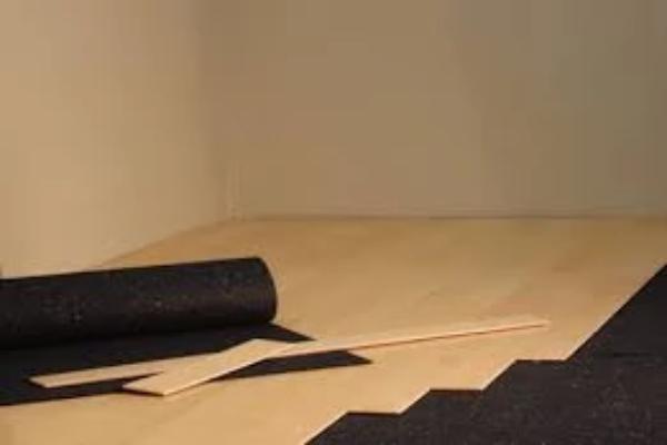 Rubber underlayment flooring roll partially unrolled under hardwood flooring installation